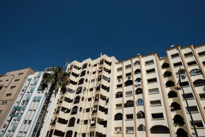 Low angle view of buildings against clear blue sky