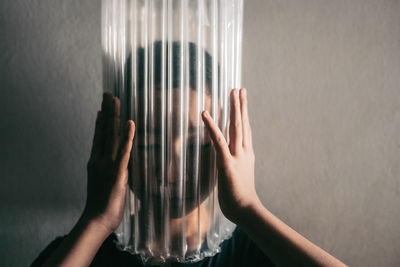 Boy wearing bubble wrap on face against wall