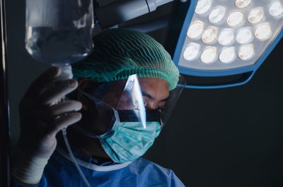 Surgeon examining iv drip in operating room