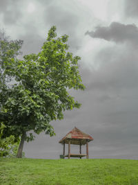 Gazebo by tree against sky