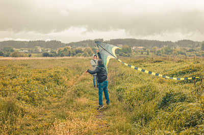 Rear view of man standing on land against sky