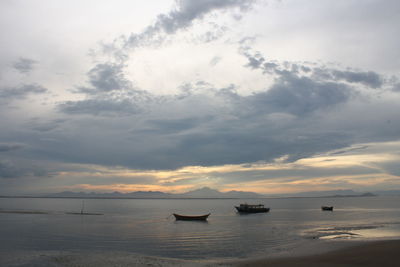 Boats sailing on sea against sky during sunset