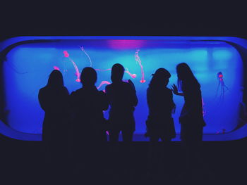 Silhouette people in aquarium