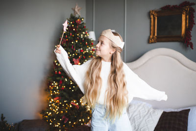 Rear view of woman holding christmas tree