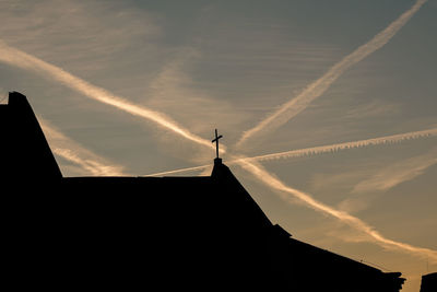 Low angle view of silhouette building against sky