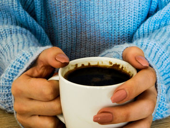 Close-up of hand holding coffee cup