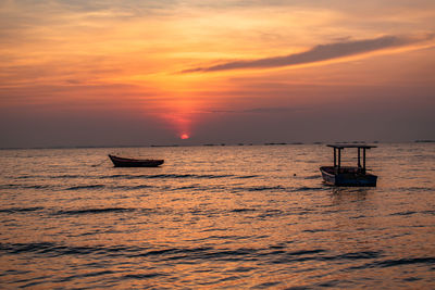 Silhouette boat in sea against sky during sunset