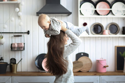 Side view of young woman standing at home