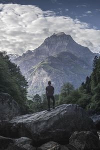 Rear view of man looking at mountain against sky