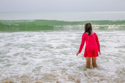 Rear view of woman standing on beach