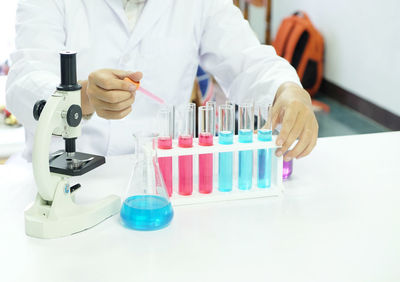 Midsection of male scientist experimenting in laboratory