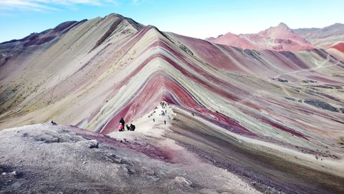 Panoramic view of people on snowcapped mountain against sky