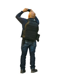 Rear view of man photographing against white background