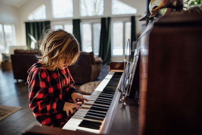 Little boy with messy hair playing the piano