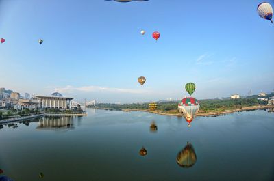 Hot air balloons flying over lake
