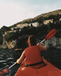 Rear view of man on boat against sky