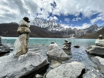 Stack of rocks in water against sky
