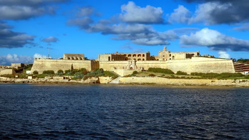 Historic building by sea against sky