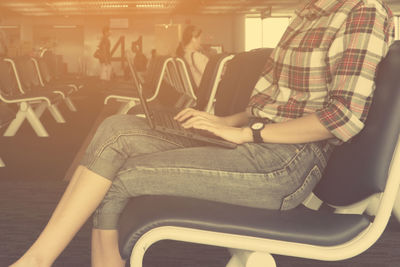 Side view of a woman sitting on chair