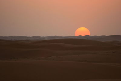 Scenic view of desert against sky during sunset