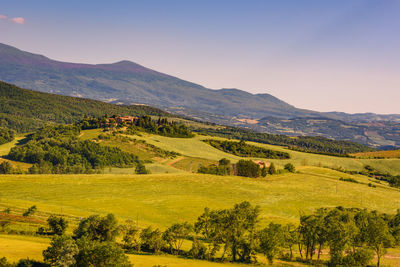 Scenic view of field and mountains against clear sky