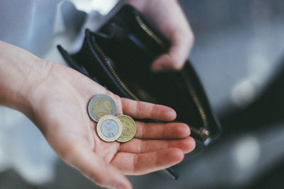 Close-up of hand holding coins