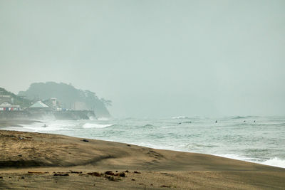 Scenic view of beach against foggy sky