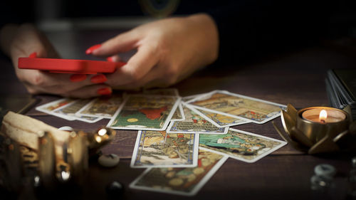Cropped hand of person holding jigsaw pieces on table