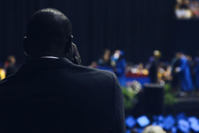 Rear view of man at graduation ceremony in school building