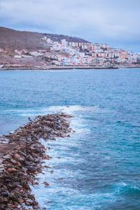 Barrier of stones going into the ocean on the coast of las palmas