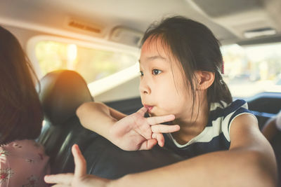 Girl with mother sitting in car