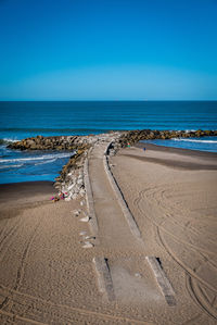 Scenic view of beach against blue sky