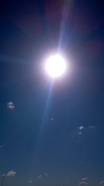 Low angle view of sun shining in blue sky