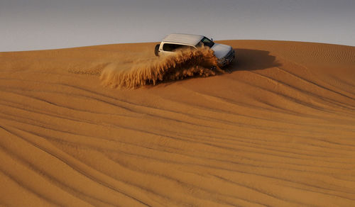 Off-road vehicle moving on sand at desert