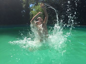 Child jumping swimming in pool