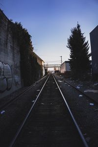 Railroad tracks in city against clear sky