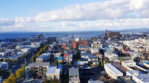 High angle view of townscape by sea against sky