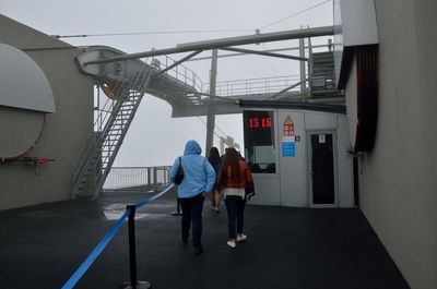 Rear view of people walking on road