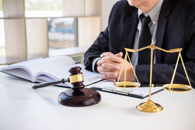 Midsection of man holding camera on table