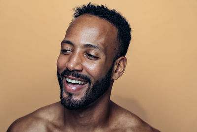 Close-up of young man against pink background