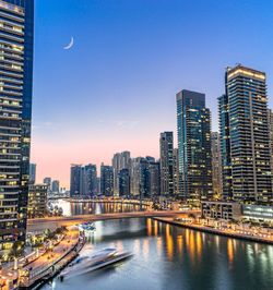 Illuminated cityscape against sky at night