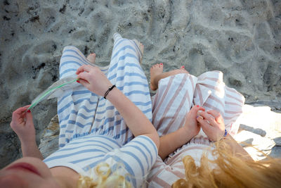 Low section of woman lying on sand