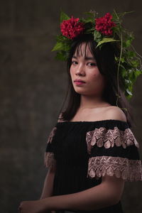 Portrait of beautiful woman standing against pink flower