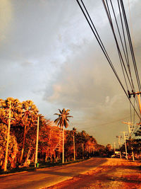 Electricity pylon against cloudy sky