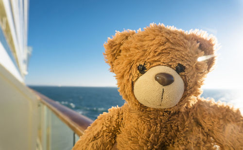 Close-up of stuffed toy by sea against sky