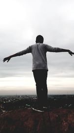 Rear view of man standing on landscape against sky