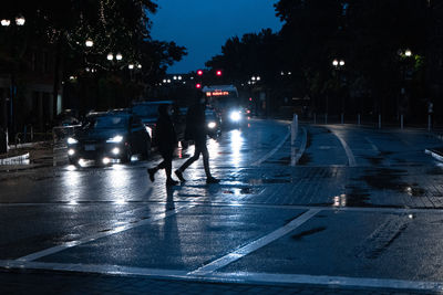 People on road in city at night