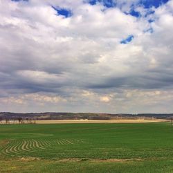 Scenic view of field against cloudy sky