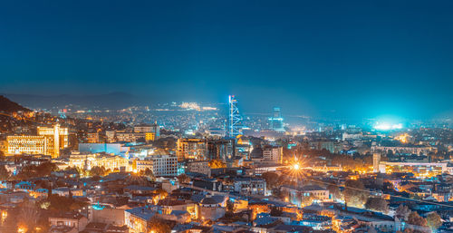 High angle view of city lit up at night
