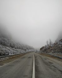 Empty road against sky during winter